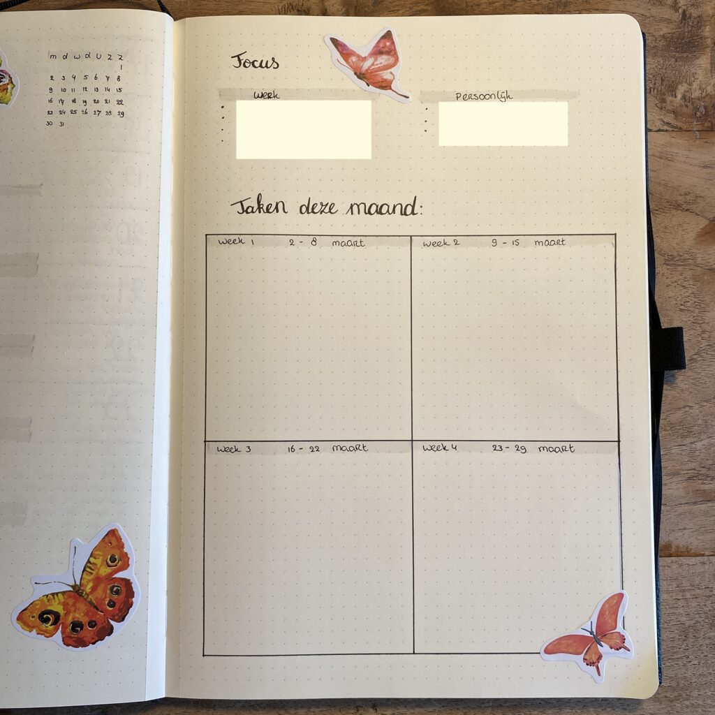 Open notitieboek met weekoverzicht en vlinderstickers op hagelwit papier