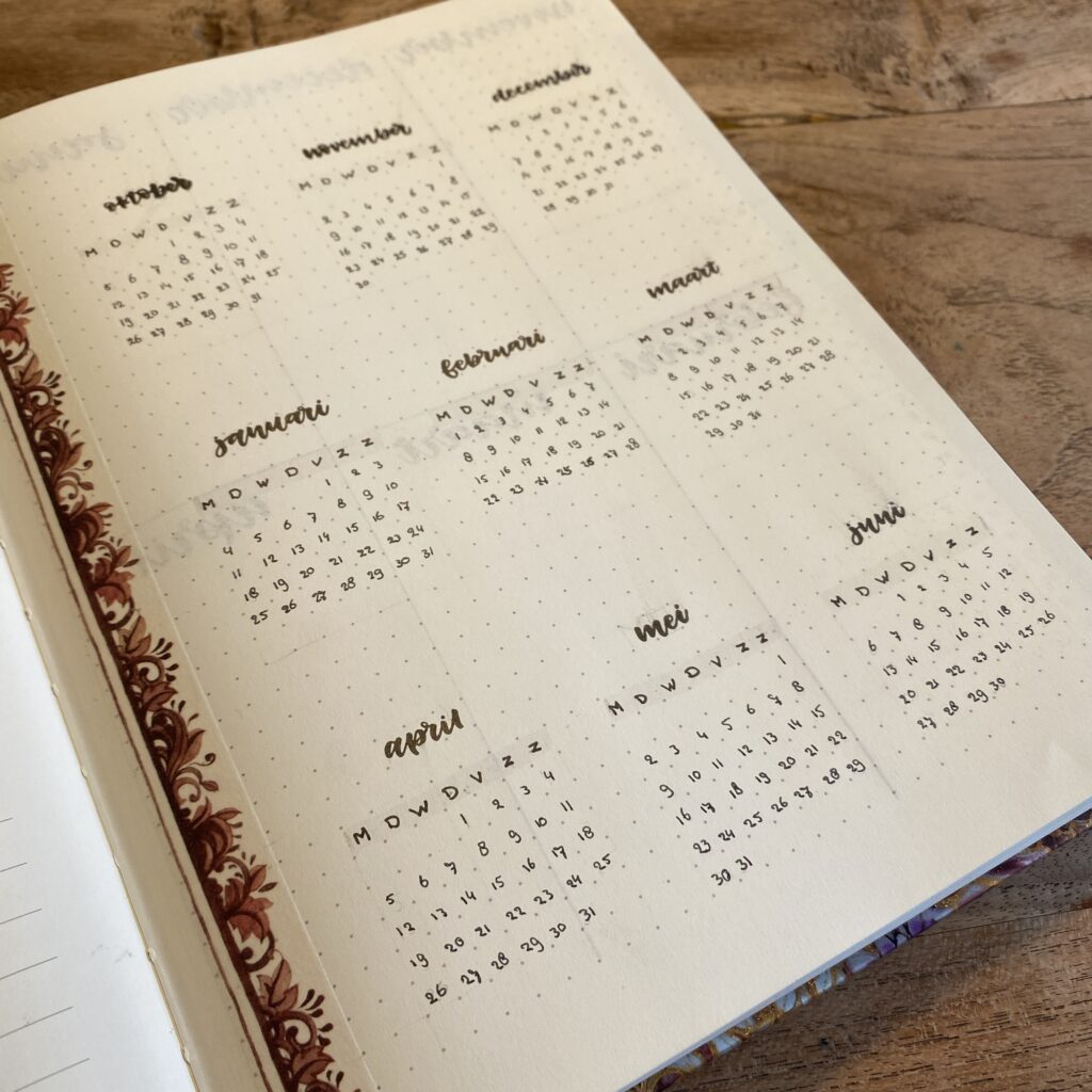 Open notitieboek met jaaroverzichtspagina op houten oppervlak