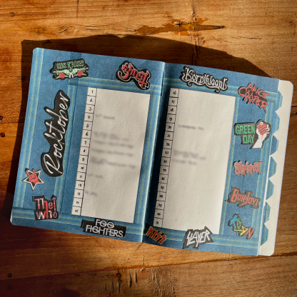 Open notitieboek met banden van rockbands op blauwe achtergrond