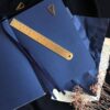 Blauw notitieboek met lint en gouden liniaal op donkere achtergrond