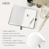 Open notitieboek met wit papier en pen op tafel