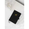 Zwart notitieboek met gouden koala-afbeelding op wit geruit papier