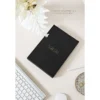 Zwarte geschenkdoos van Scribble & Dot op een bureau met witte bloemen