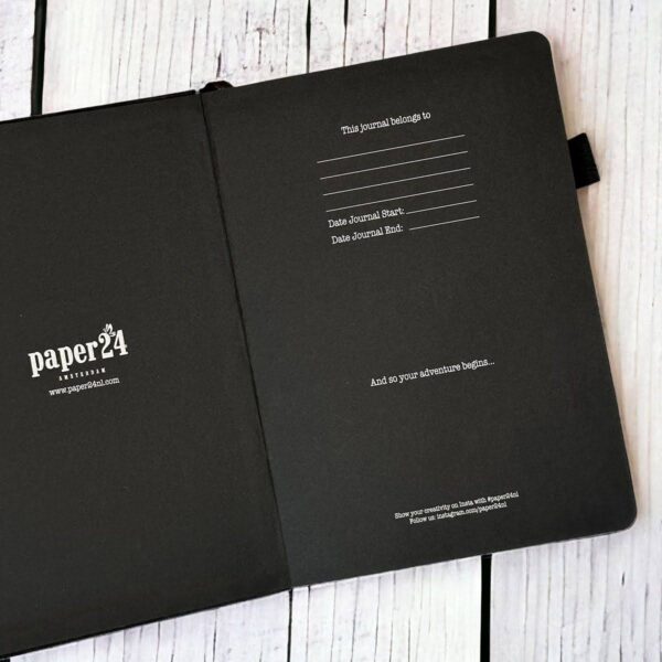 Zwart notitieboek van Paper24 open op wit houten oppervlak