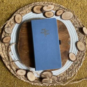 Blauw notitieboek met reispijler-ontwerp op houten bord