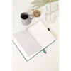 Open notitieboek met witte pagina's op een witte tafel