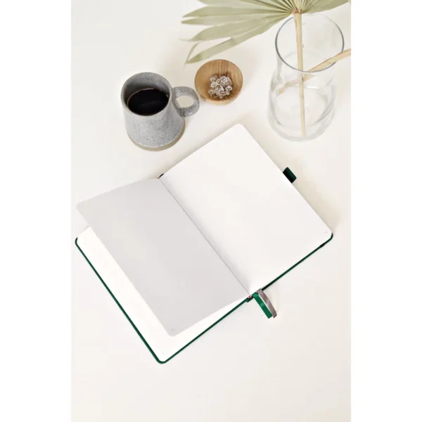 Open notitieboek met witte pagina's op een witte tafel