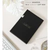 Zwart geschenkdoosje van Scribble & Dot op een lichte ondergrond