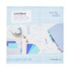Labelblok van Nienke Vletter met pastelkleurige labels en schrijfaccessoires op blauw geruit papier