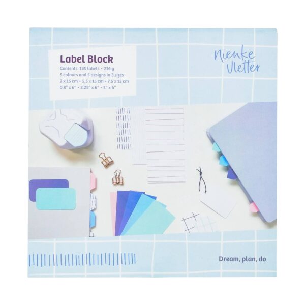 Labelblok van Nienke Vletter met pastelkleurige labels en schrijfaccessoires op blauw geruit papier