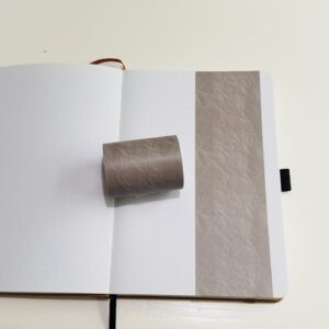 Bruine washi tape op een open notitieboek met puntjes