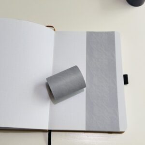 Grijze washi tape op een open notitieboek met puntjes
