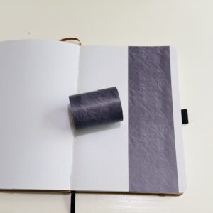 Paarse washi tape met gekreukelde textuur op open notitieboek
