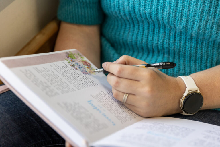Persoon schrijft in een notitieboek met een pen
