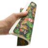 9780349715025 Nani - Dot Grid - A5 - Back Hand houdt een notitieboek vast met tropisch blad- en bloemendessin op zwarte achtergrond