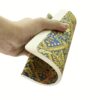 Hand houdt een notitieboek vast met blauw-gouden patroon en witte pagina's
