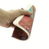 Hand houdt een gebogen notitieboek vast met een kleurrijke vogelillustratie op de rug